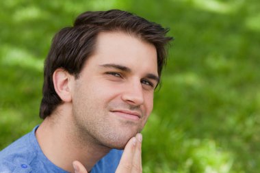 Young handsome man thoughtfully looking at the camera clipart