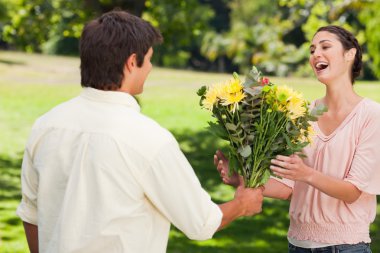 Man presents his friend with flowers clipart