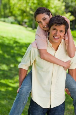 Woman with her hand on her friends head as he is carrying her clipart