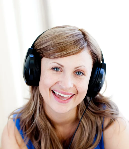 Mulher bonito está ouvindo a música com fones de ouvido — Fotografia de Stock