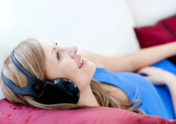 Mulher alegre está ouvindo a música com fones de ouvido — Fotografia de Stock