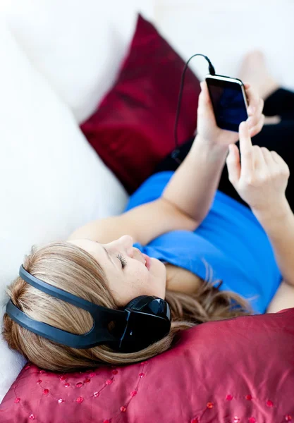 Mujer encantada está escuchando la música con auriculares — Foto de Stock