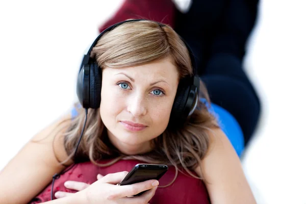 Mulher atraente está ouvindo a música com fones de ouvido — Fotografia de Stock