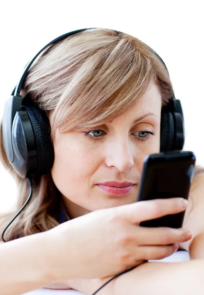 Mujer encantadora está escuchando la música con auriculares —  Fotos de Stock