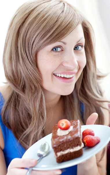 Χαρούμενα γυναίκα που κρατά ένα κομμάτι κέικ σοκολάτας — Φωτογραφία Αρχείου