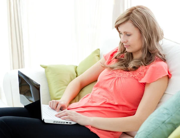 Koncentrovaná žena s notebookem sedět na pohovce — Stock fotografie