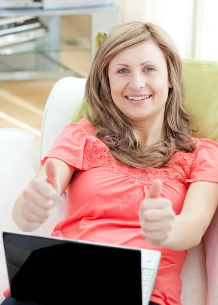 Επιτυχημένη γυναίκα χρησιμοποιώντας ένα φορητό υπολογιστή, καθμένος σε έναν καναπέ — Φωτογραφία Αρχείου