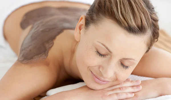 Charming woman enjoying a mud skin treatment — Stock Photo, Image