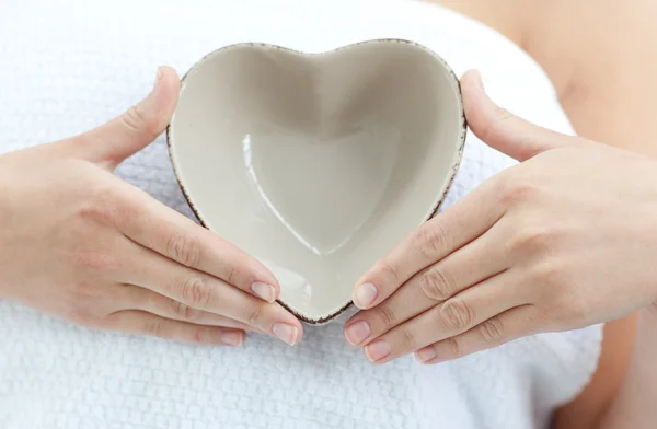 Close-up of a woman holding a bowl in the shape of a heart — Stock Photo, Image
