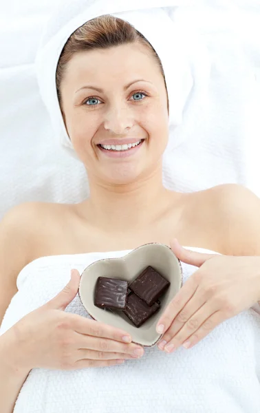 Fröhliche Frau hält eine Schale in Herzform mit Schokolade in der Hand — Stockfoto