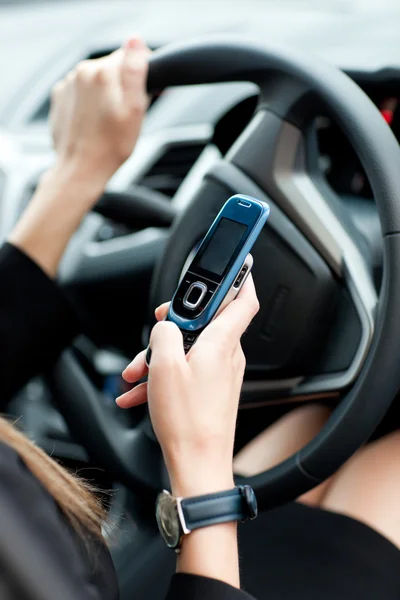 Close-up of a businesswoman sending a text while driving — Stock Photo, Image