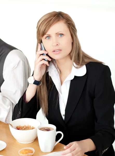 Femme d'affaires inquiète parler au téléphone tout en prenant le petit déjeuner — Photo