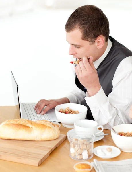 Обаятельный бизнесмен с ноутбуком во время завтрака — стоковое фото