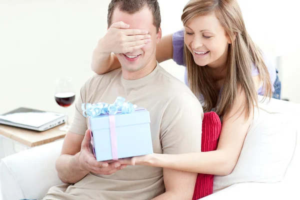 Lächelnde Frau schenkt ihrem Freund ein Geschenk — Stockfoto