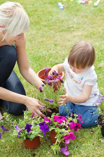 Glowing mother and her daughter with flowers — Stock Photo, Image