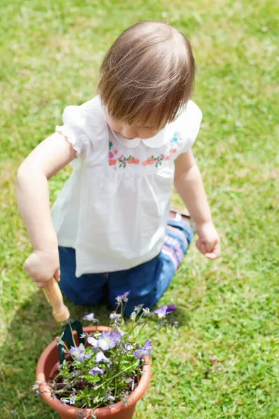 Menina bonito segurando uma ferramenta de jardim — Fotografia de Stock