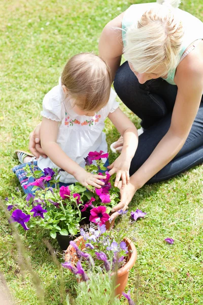 Sweet child helping her mother in the garden — Stock Photo, Image