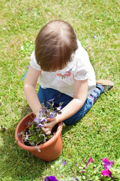 Солодка дівчина посадила квітку — стокове фото