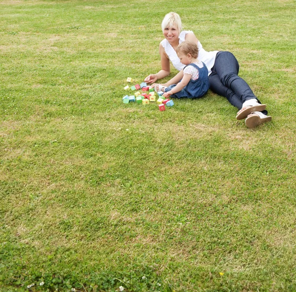 Familie liggend in het gras — Stockfoto