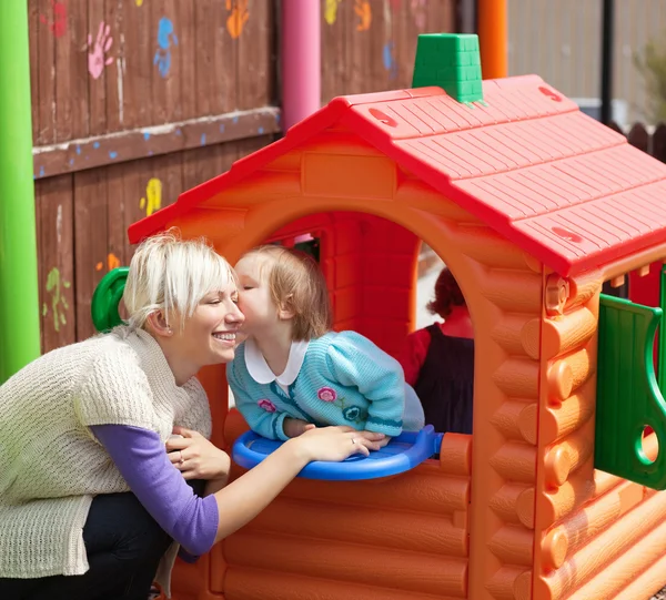 Leuk meisje kuste haar lachende moeder — Stockfoto