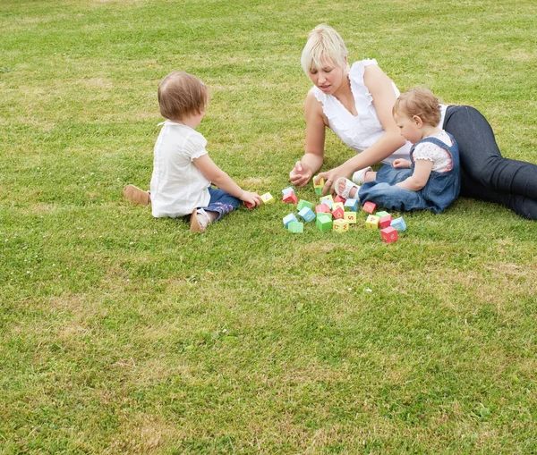 잔디에 앉아 가족 — 스톡 사진