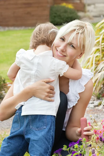 Pequena criança abraçar sua mãe sorridente — Fotografia de Stock