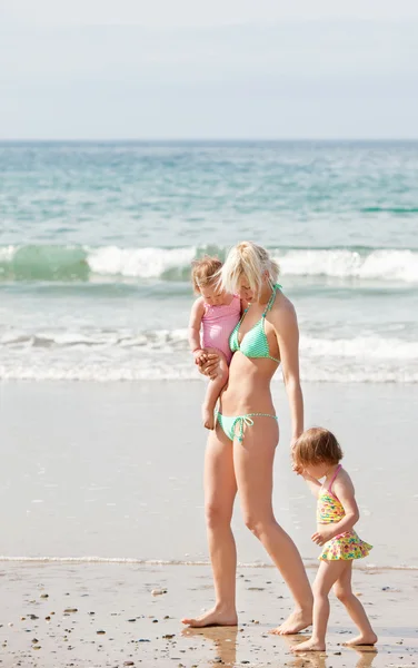 Çocukları ile sahilde yürüyen genç bir anne — Stok fotoğraf