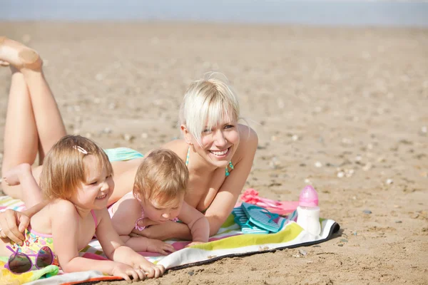 Een lachende familie liggen op het strand — Stockfoto