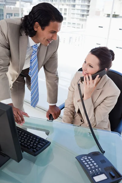 Porträt einer Geschäftsfrau am Telefon während der Arbeit mit einem Mitarbeiter — Stockfoto