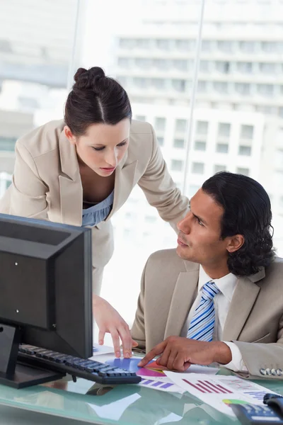 Porträt eines Wirtschaftsteams, das Statistiken studiert, während es einen Monitor benutzt — Stockfoto