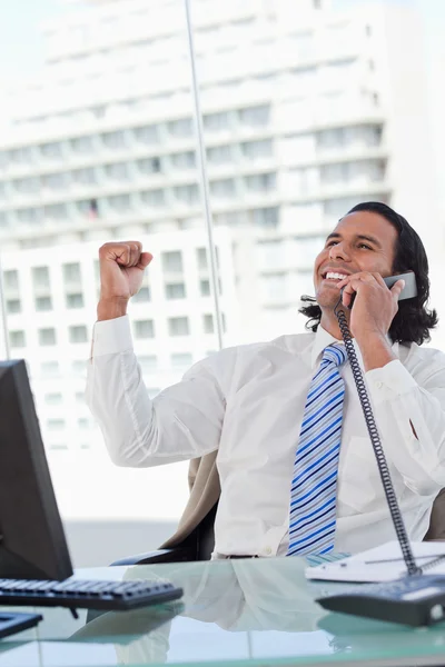 Retrato de un empresario encantado al teléfono con el puño en alto — Foto de Stock