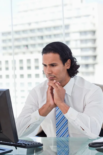 Retrato de un hombre de negocios pensando mientras usa un monitor — Foto de Stock