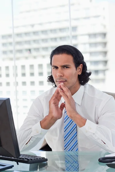 Portrait of a businessman thinking while looking at the camera — Stock Photo, Image