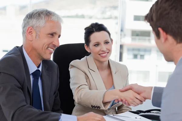 Equipe de negócios sorridente concluindo um acordo com um cliente — Fotografia de Stock