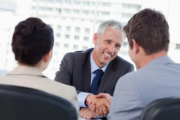Entrepreneurs shaking the hand of their banker — Stock Photo, Image