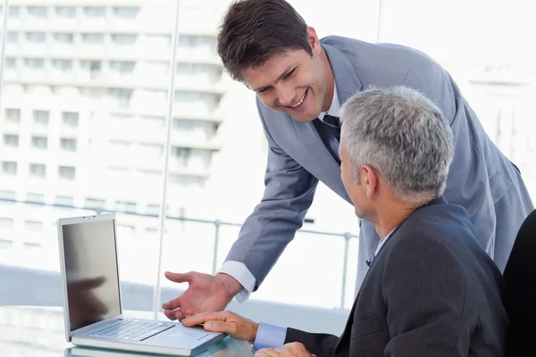 Seitenansicht lächelnder Geschäftsleute, die mit einem Notizbuch arbeiten — Stockfoto