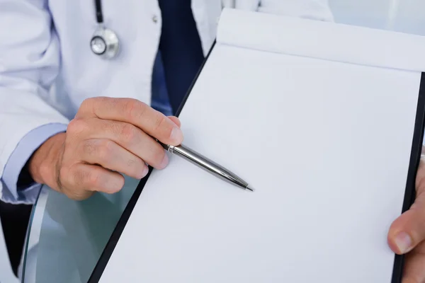Крупним планом чоловічий лікар, який показує порожній документ — стокове фото