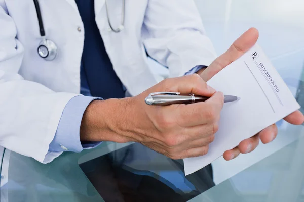 Close up of a male doctor showing a blank prescription sheet — Stock Photo, Image