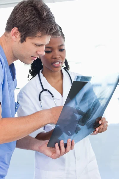 Portrait of serious doctors looking at a of X-ray — Stock Photo, Image