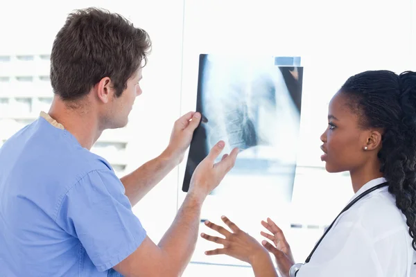 Unga läkare titta på en av röntgen — 图库照片