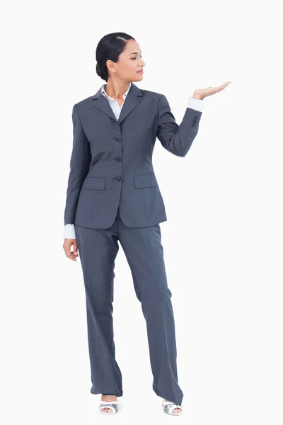 Geschäftsfrau präsentiert mit erhobener Hand — Stockfoto