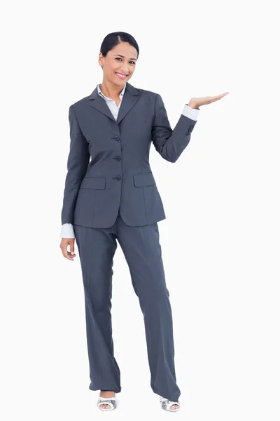 Lächelnde Geschäftsfrau präsentiert mit erhobener Hand — Stockfoto