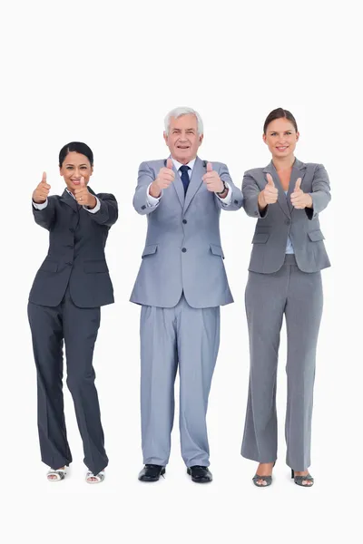 Three smiling businesspeople giving thumbs up — Stock Photo, Image