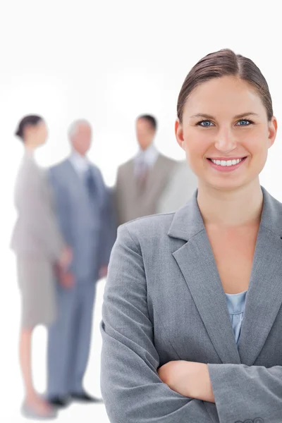 Lächelnde Geschäftsfrau mit ihren Kollegen im Rücken — Stockfoto