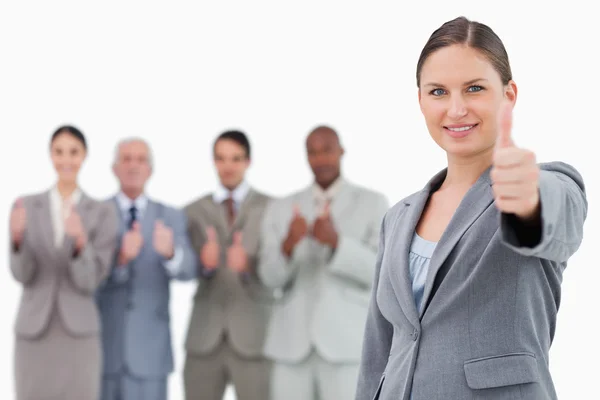 Businesswoman with thumb up and colleagues behind her — Stock Photo, Image