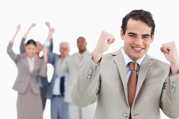 Empresário sorridente com equipe atrás dele levantando punhos — Fotografia de Stock