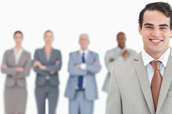 Smiling salesman with his team behind him — Stock Photo, Image