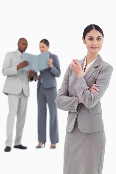 Saleswoman with co-workers behind her — Stock Photo, Image
