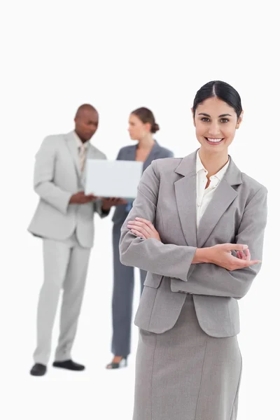 Saleswoman with talking colleagues behind her — Stock Photo, Image