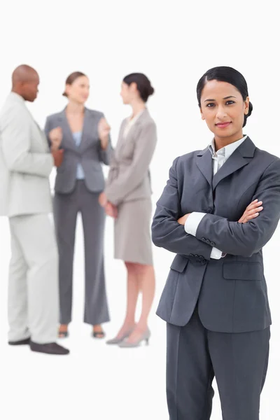 Saleswoman with negotiating trading partners behind her — Stock Photo, Image